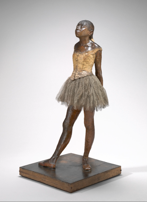 "La Petite Danseuse de Quatorze Ans", cera amarilla, pelo, cinta, blusa de lino, zapatros de raso, tutú de muselina. Base de madera negra, creada por  Edgar Degas, 1878-1881 y exhibida en la National Gallery of Art (Washington). .